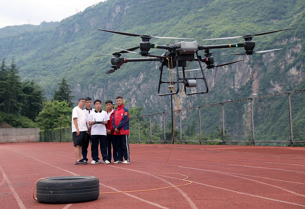 Students practice drone lifting operations under their instructor's guidance on the sports field of Ebian Yi Autonomous County Vocational Senior High School in Leshan, Sichuan Province, June 9, 2025. /CFP