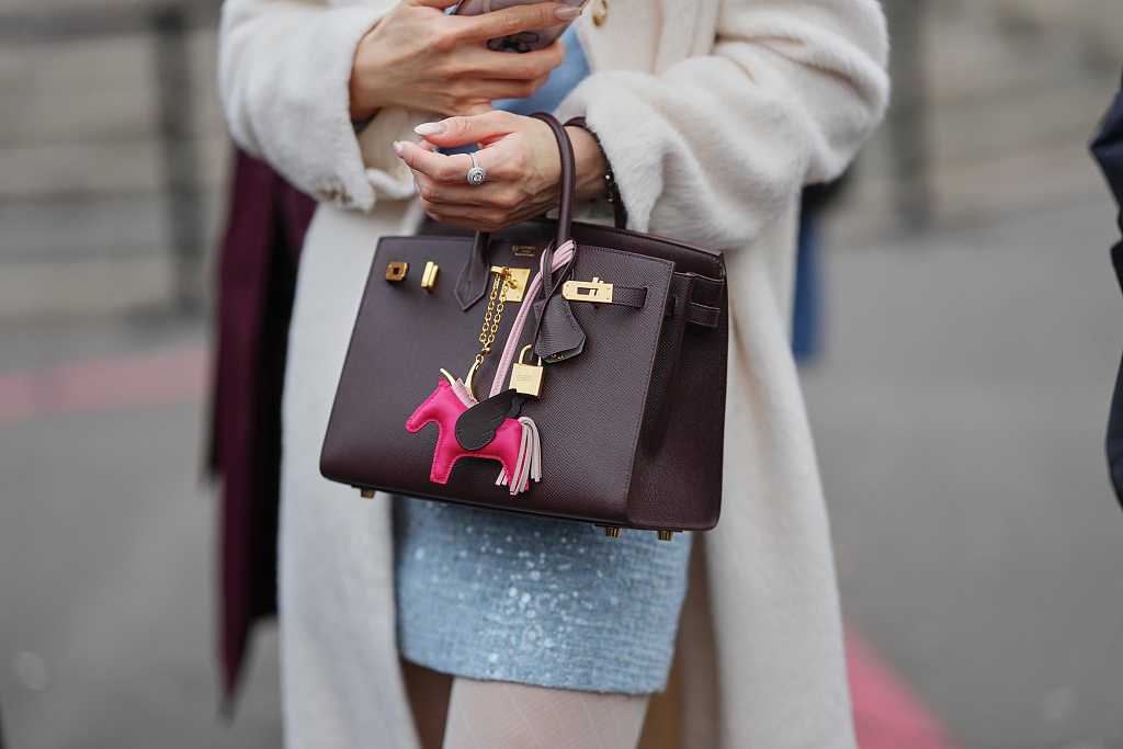 A Hermès Birkin handbag adorned with a pink Hermès Rodeo horse and leather tassel accents. /VCG
