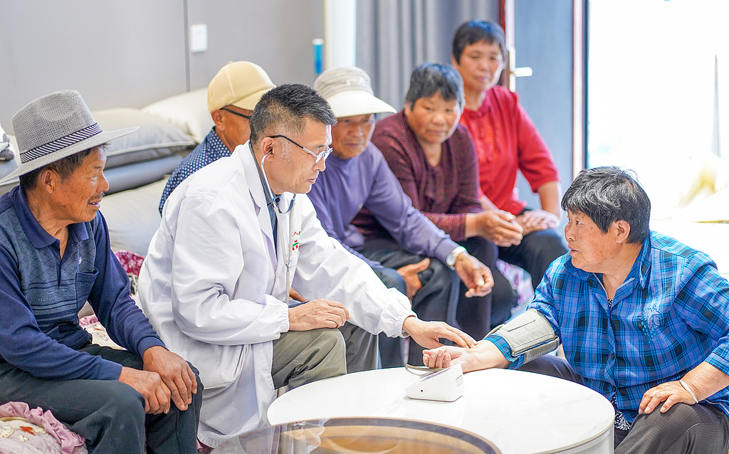 A doctor provides home-based medical services, measuring a resident's blood pressure and offering medication guidance in Suqian City, east China's Jiangsu Province. /VCG