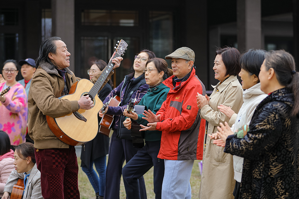 Seniors attend a guitar class at a community senior care service center in Qingdao City, east China's Shandong Province. /VCG