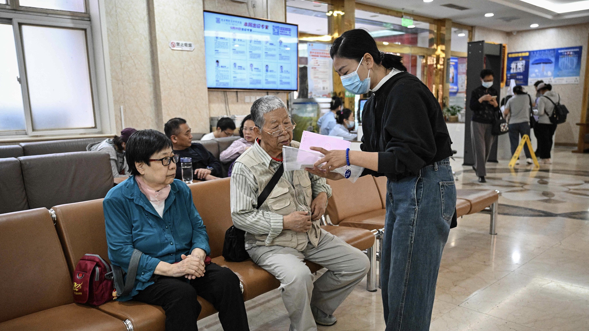 A hospital companion explains to a patient how to pick up their medication. /VCG