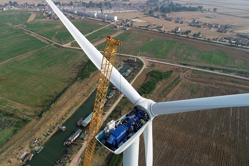 A drone aerial view shows workers carrying out the first high-altitude inspection of wind turbines in east China's Jiangsu Province, June 3, 2018. /VCG
