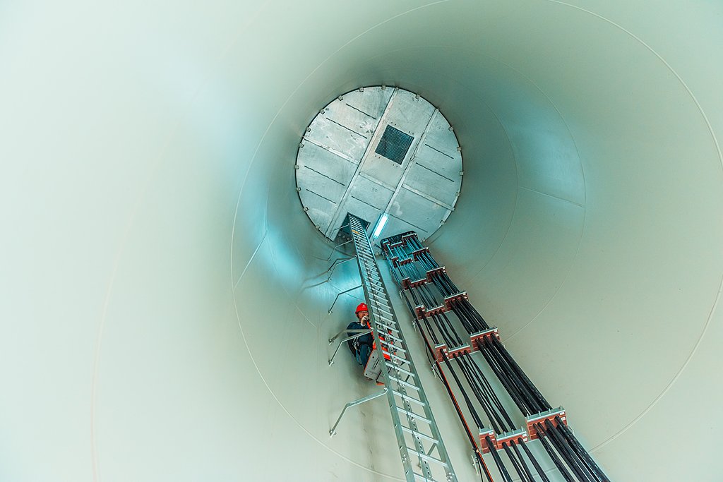Staff members carry out maintenance on a wind power generator in central China's Hubei Province, July 13, 2022. /VCG