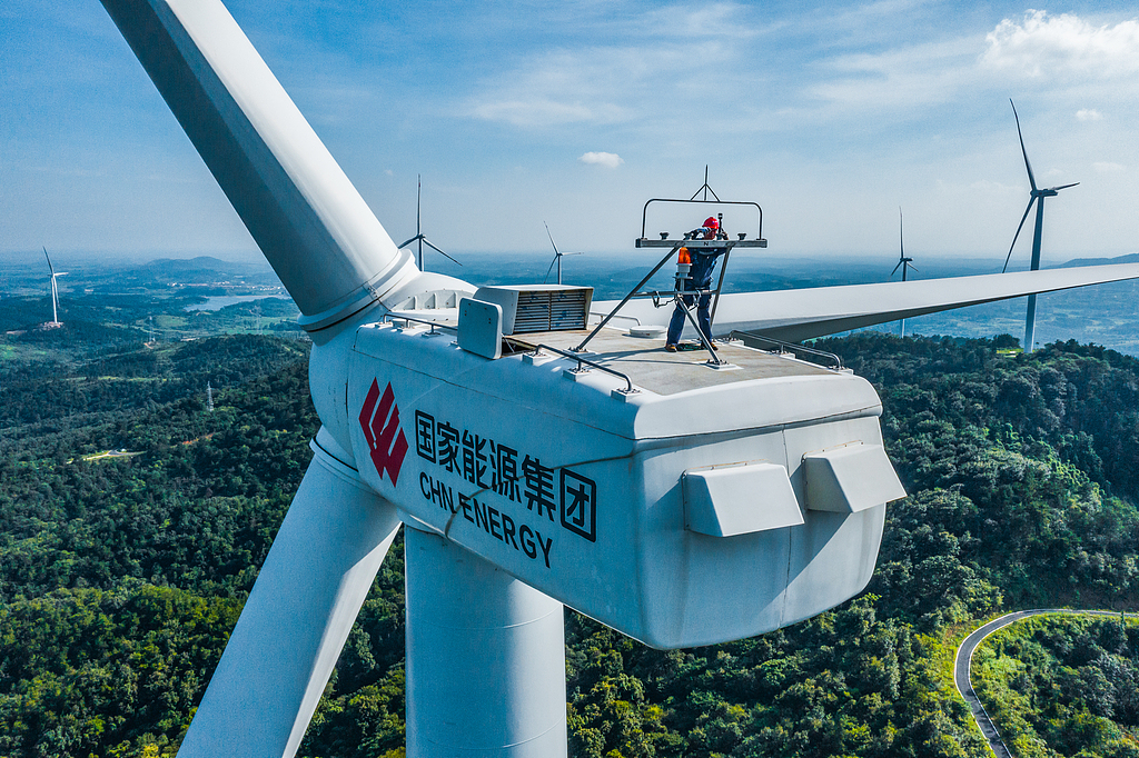 Staff members carry out maintenance on a wind power generator in central China's Hubei Province, July 13, 2022. /VCG