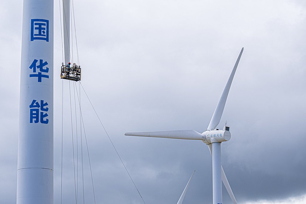 Staff members inspect wind power generation equipment in Wenchang, south China's Hainan Province, July 20, 2022. /VCG
