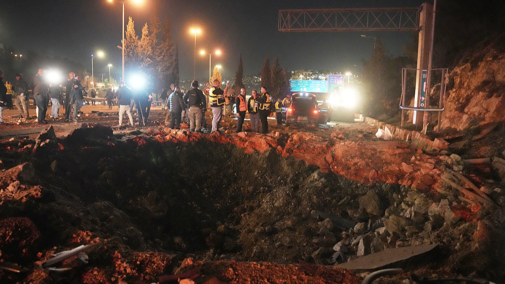 Israeli security forces inspect a damaged road after a missile launched from Iran struck Jerusalem, Israel, March 1, 2026. /VCG