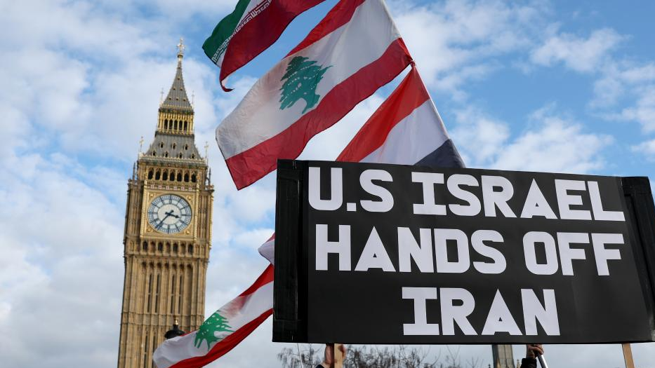 People hold a placard during a protest against US-Israeli attacks on Iran, at the Parliament Square in central London, UK, February 28, 2026. /Xinhua