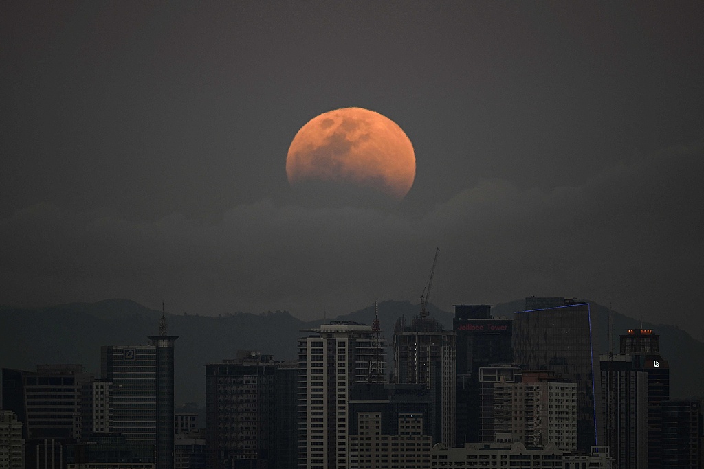 A full moon rises over buildings in Manila, Philippines, March 3, 2026. /VCG
