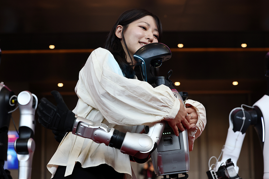 A woman interacts with a Chinese humanoid robot at the 2026 Smart Factory & Automation Fair at the COEX Convention Center in Seoul, South Korea, 4 March 2026./VCG