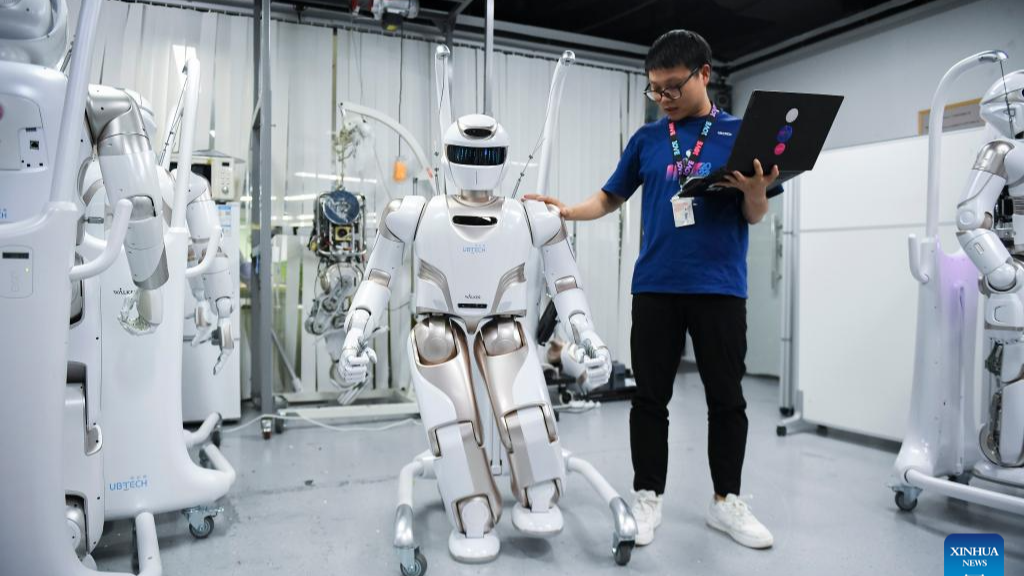 A staff member conducts tests on a Walker X humanoid robot at a sci-tech company in Shenzhen, south China's Guangdong Province, June 26, 2024. /CFP
