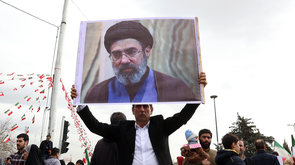 An Iranian man holds a picture of Mojtaba Khamenei as he takes part in celebrations of the 47th anniversary of the Islamic Revolution in Tehran, Iran, February 11, 2026. /VCG