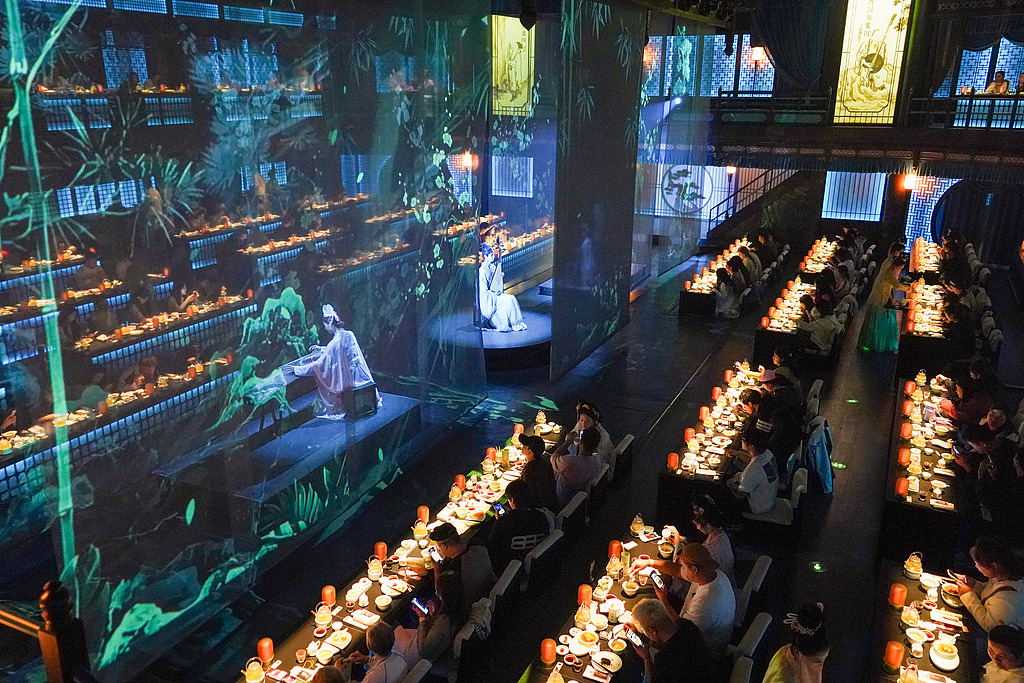 Performers in ancient costumes entertain guests at the Qingming Riverside Landscape Garden in Kaifeng, Henan Province, on September 26, 2025. /VCG