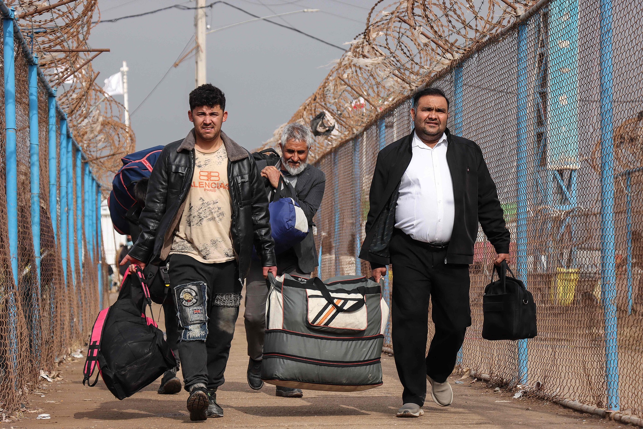 Afghan nationals walk with their belongings upon their arrival from Iran at the Islam Qala border crossing between Afghanistan and Iran in Herat province, March 5, 2026. /VCG