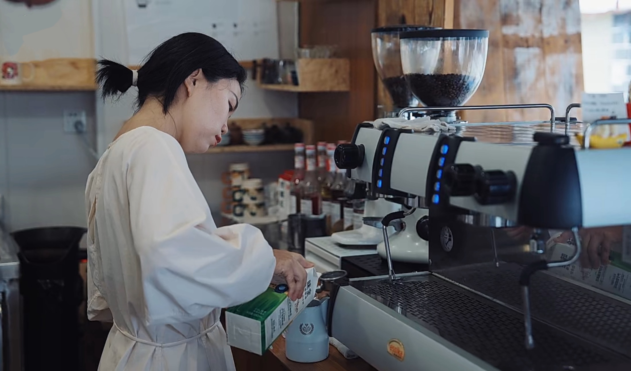 Homecoming entrepreneur Zhang Qianni makes coffee at her shop, Chengdu, Sichuan Province, southwest China. /CGTN