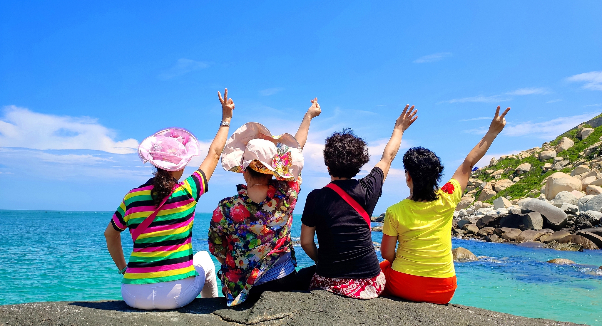 Four female travelers pose for a group photo on the sandy shores of Dongshan Island in Zhangzhou, Fujian Province on September 21, 2024. /VCG