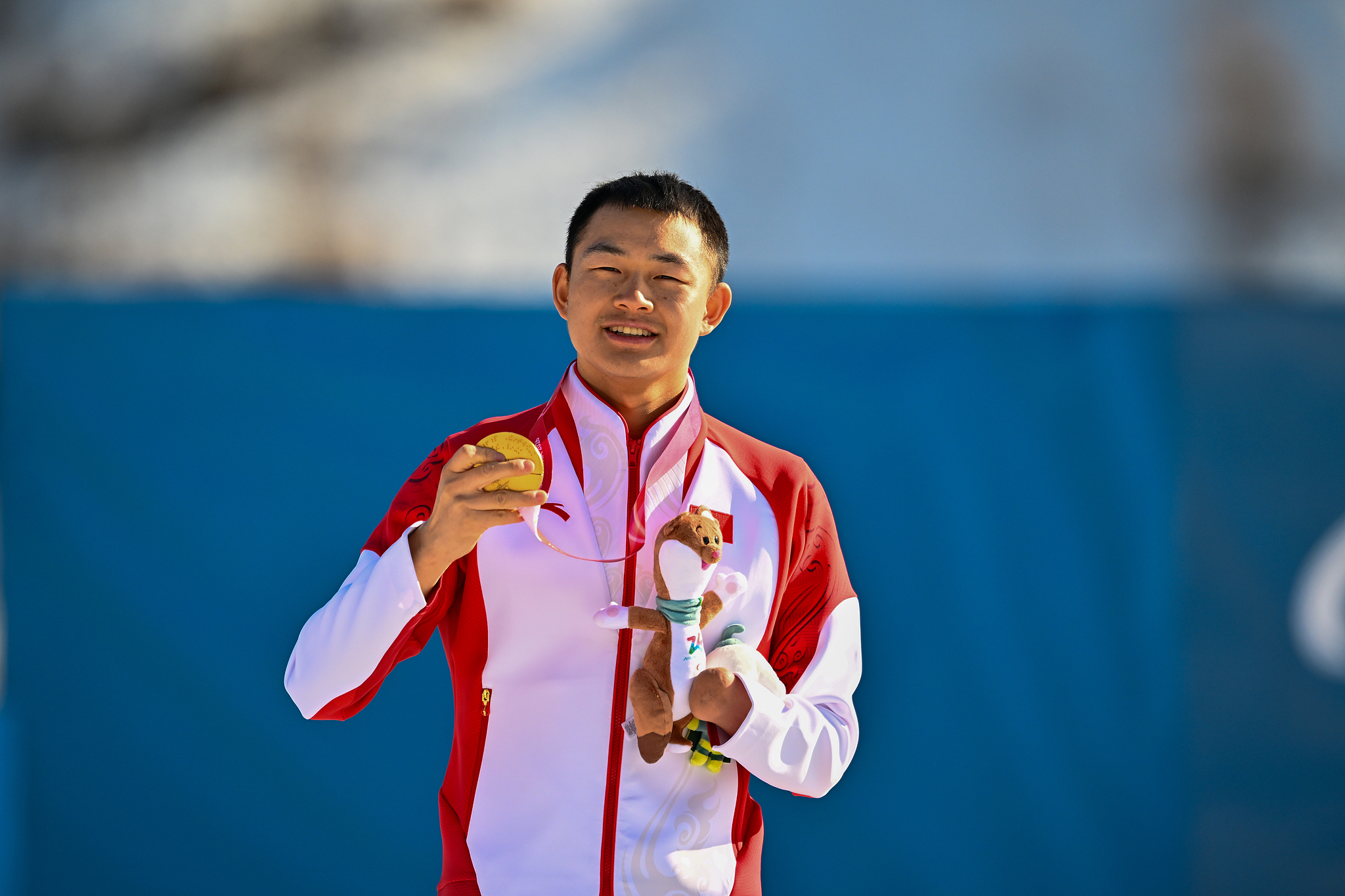Gold medalist Cai Jiayun of China shows his gold medal after winning the men's biathlon sprint standing final at the 2026 Milano Cortina Winter Paralympics in Val di Fiemme, Italy, March 7, 2026. /VCG