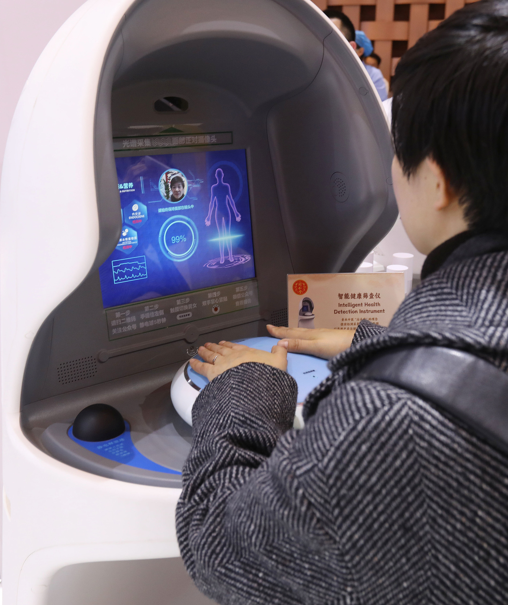 Visitors experience an intelligent traditional Chinese medicine screening device at the 2024 World Conference on Traditional Medicine, Beijing, December 2, 2024. /VCG
