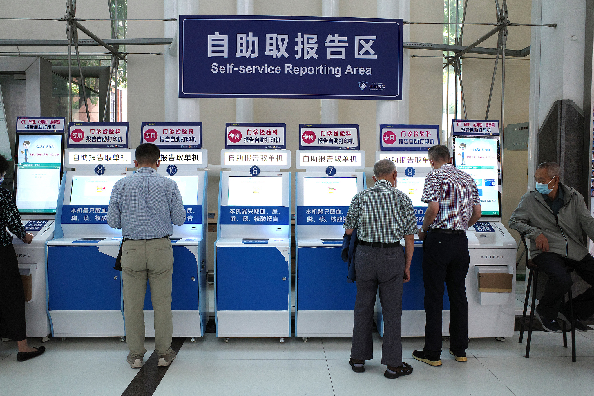 Patients complete registration, payment and check-in through self-service kiosks at Zhongshan hospital in Shanghai, June 4, 2024. /VCG