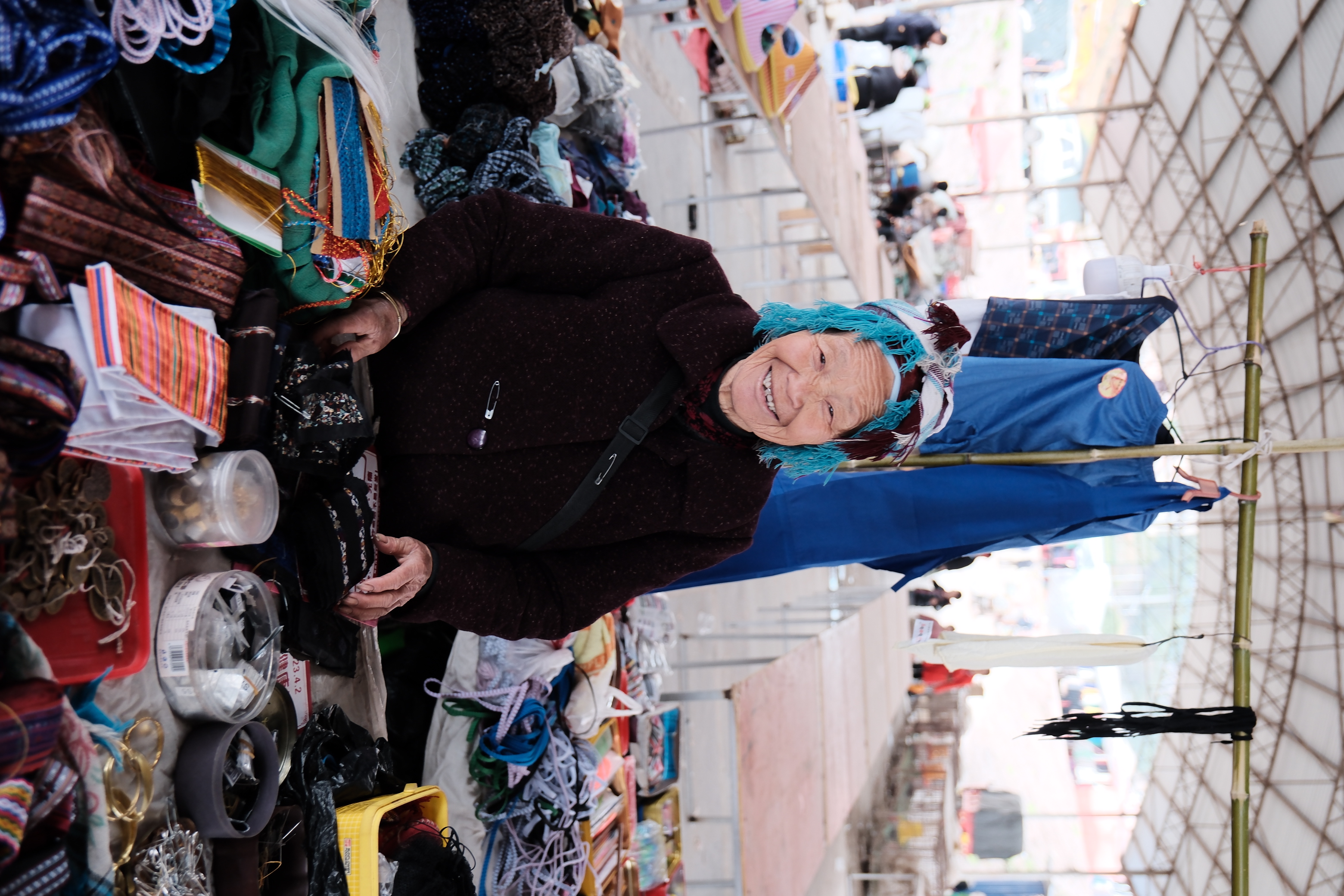 At a rural market, an elderly Miao woman sells handmade items, reflecting the small-scale trade and everyday exchanges that sustain village life. /CGTN