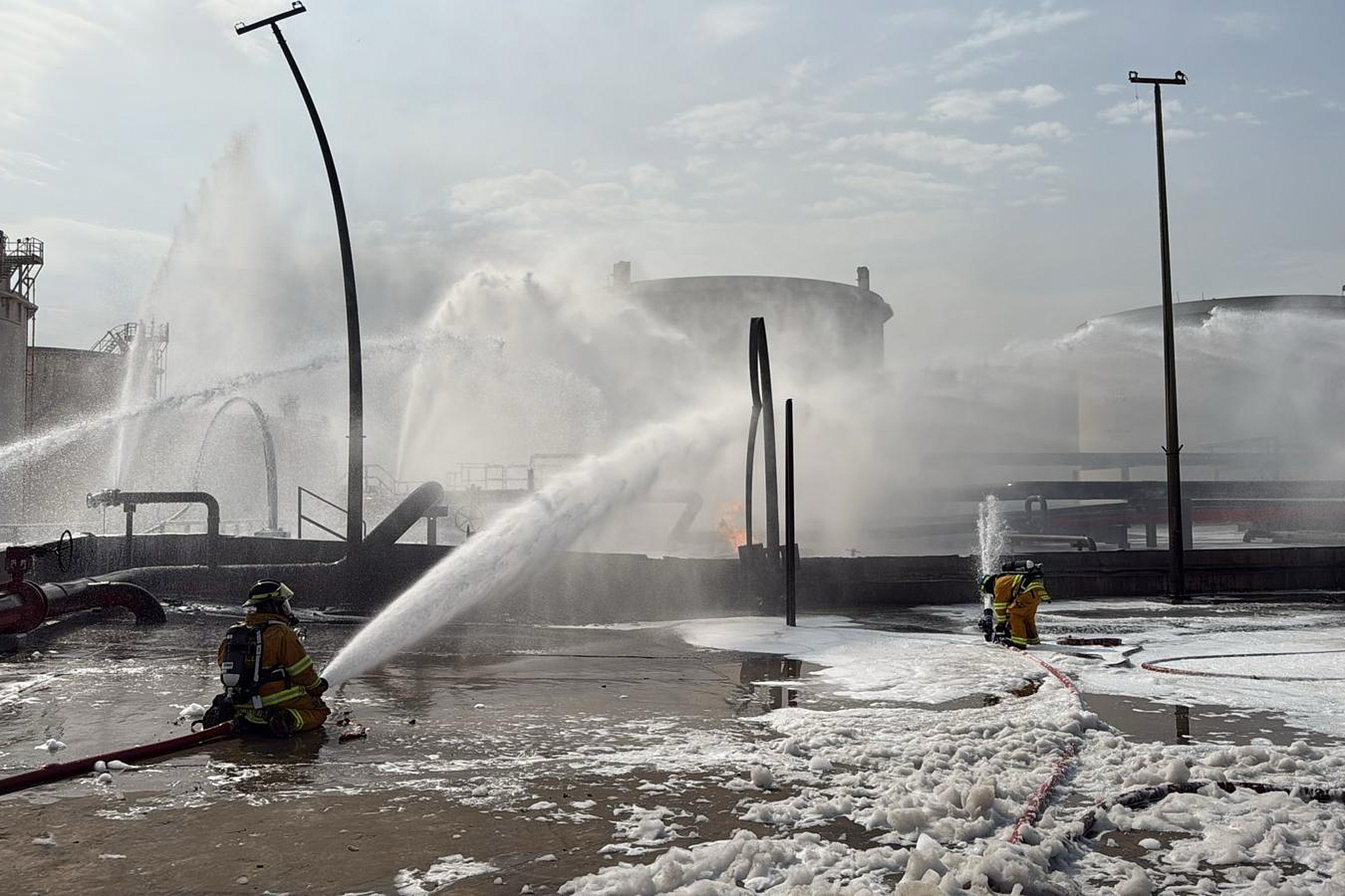 This image released by Bahrain's Interior Ministry shows firefighters extinguishing flames after an Iranian projectile struck an industrial area in Maameer, Bahrain, Monday, March 9, 2026. /VCG