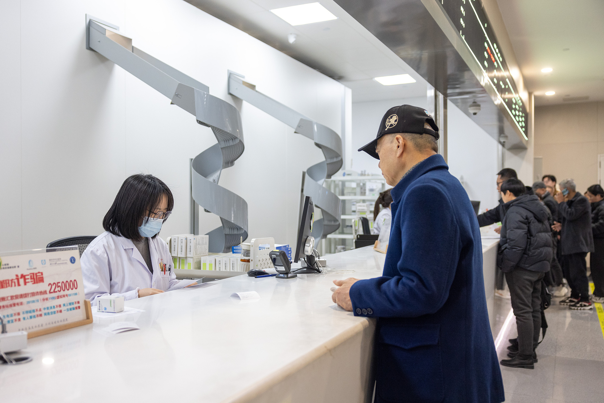 A patient collects medicine at the smart pharmacy of Huzhou Central Hospital, east China's Zhejiang Province, March 9, 2026. /CFP
