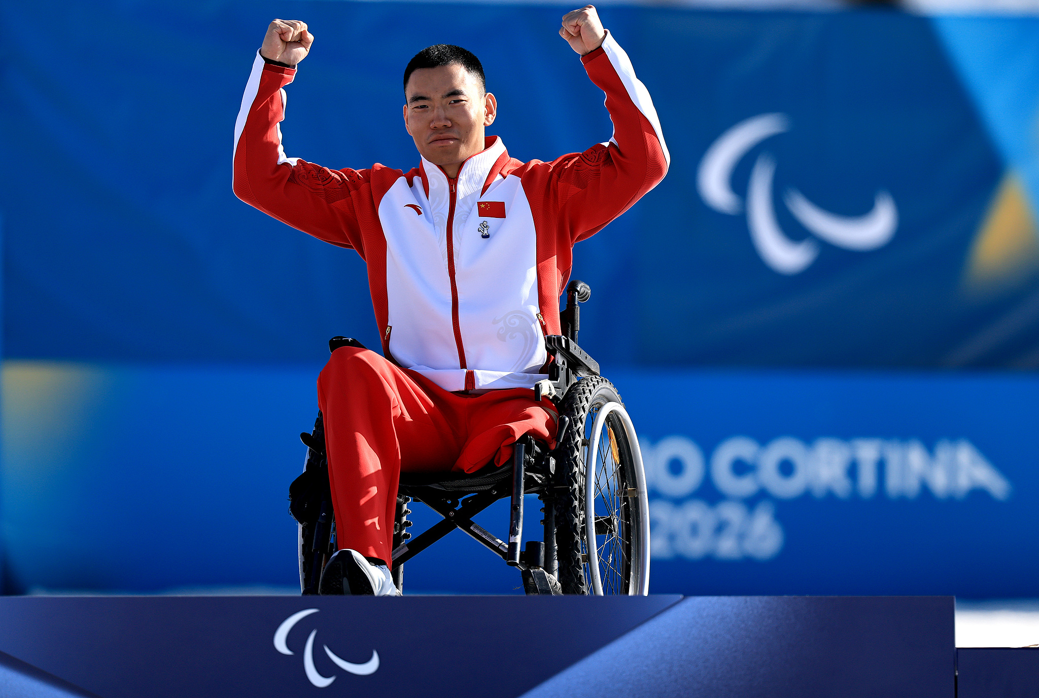 Gold medalist Liu Zixu of China celebrates on the podium during the medal ceremony for the para biathlon men's individual sitting competition at the 2026 Milano Cortina Winter Paralympics at Tesero Cross-Country Skiing Stadium in Val di Fiemme, Italy, March 8, 2026. /VCG