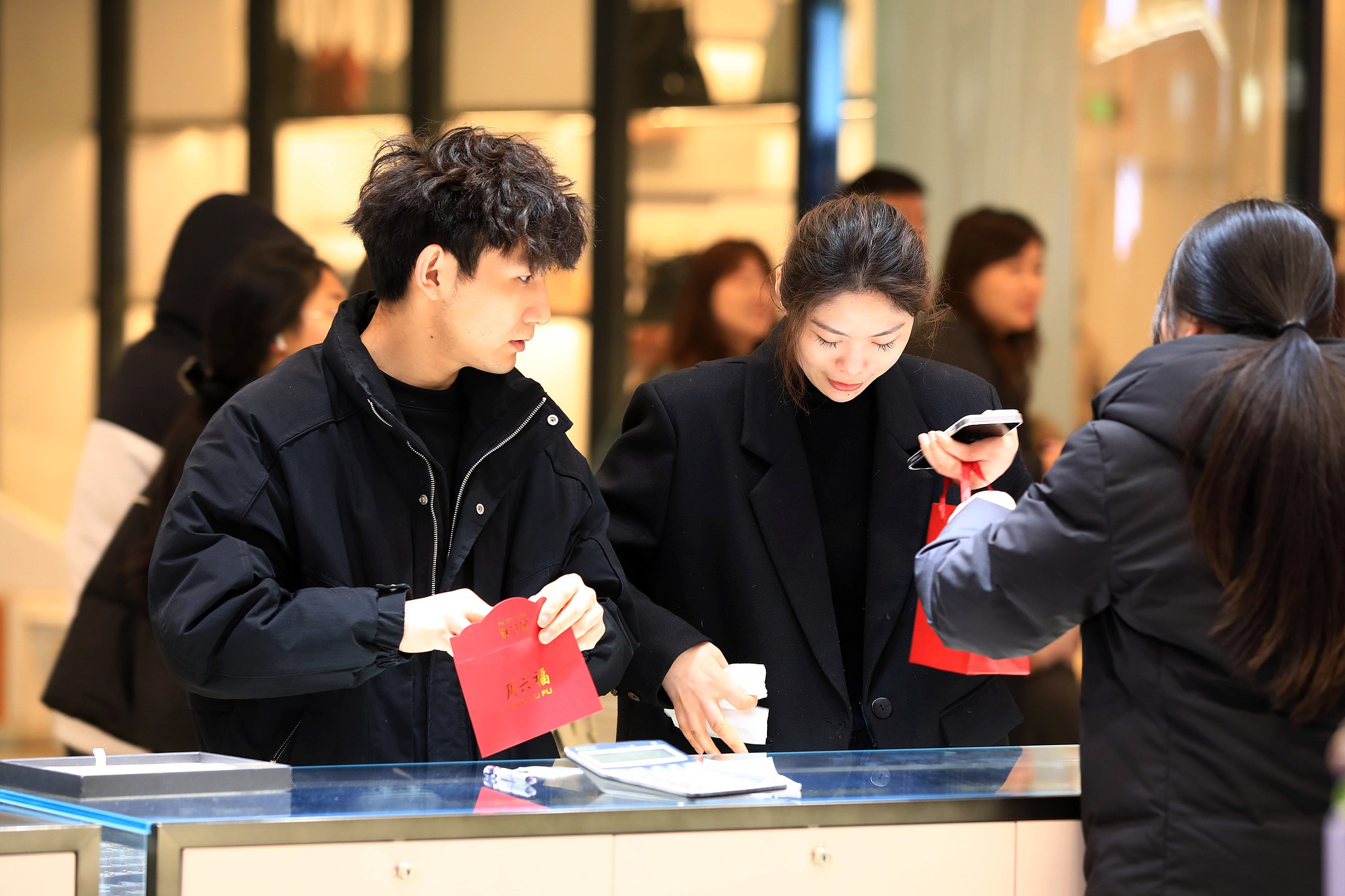 Shoppers choose gold jewelry at a shopping mall in Huai'an, east China's Jiangsu Province, March 8, 2026. /VCG