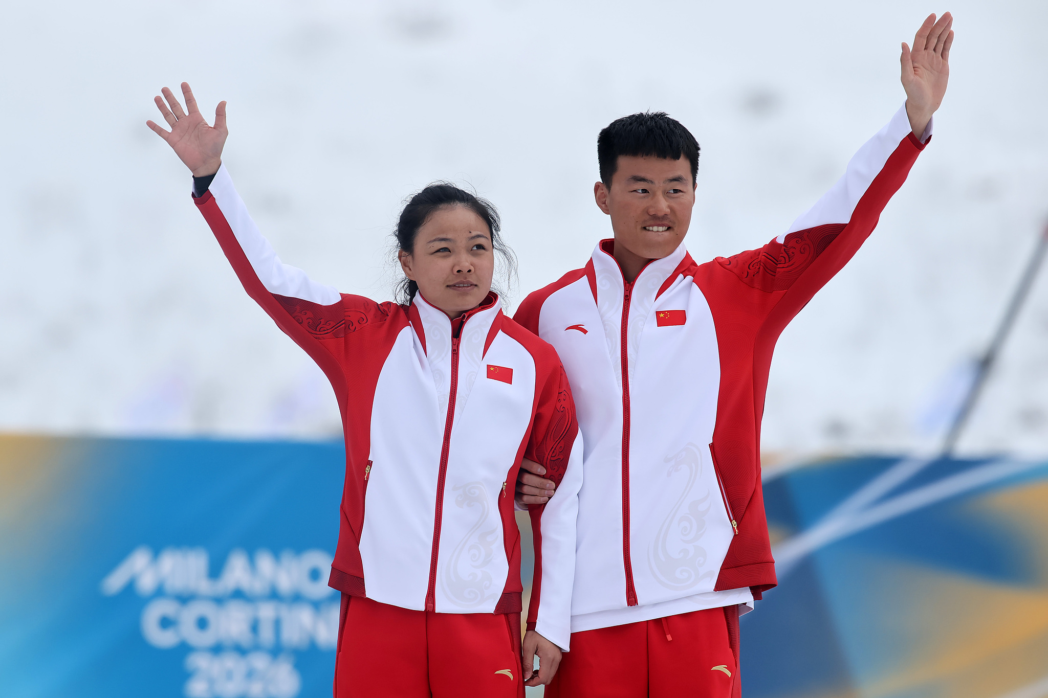 Bronze medalist Cong Jihong of Team People's Republic of China and guide Liu Jiaxuan celebrate during the medal ceremony for women's sprint classic vision impaired of the 2026 Milano Cortina Winter Paralympics in Val di Fiemme, Italy, March 10, 2026. /VCG