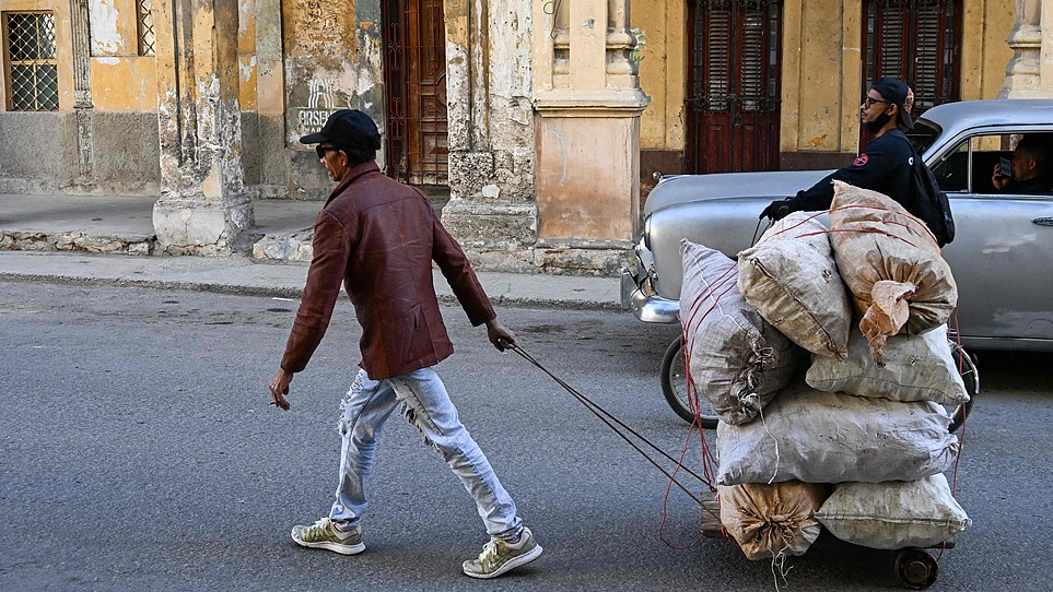 A man transports raw materials in a self-made wheelbarrow along a street due to fuel shortages in Havana, Cuba, February 25, 2026. /VCG