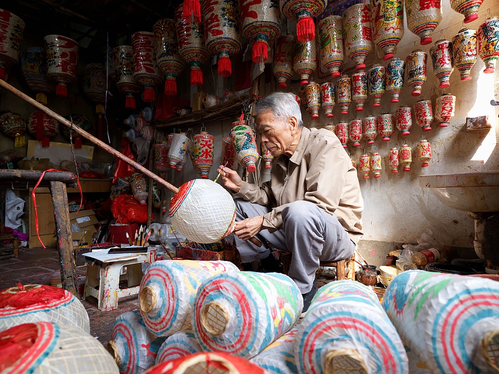 Artisan Zhuang Wenjia paints a dragon and tiger lantern in Xiamen, Fujian, March 7, 2026. /VCG