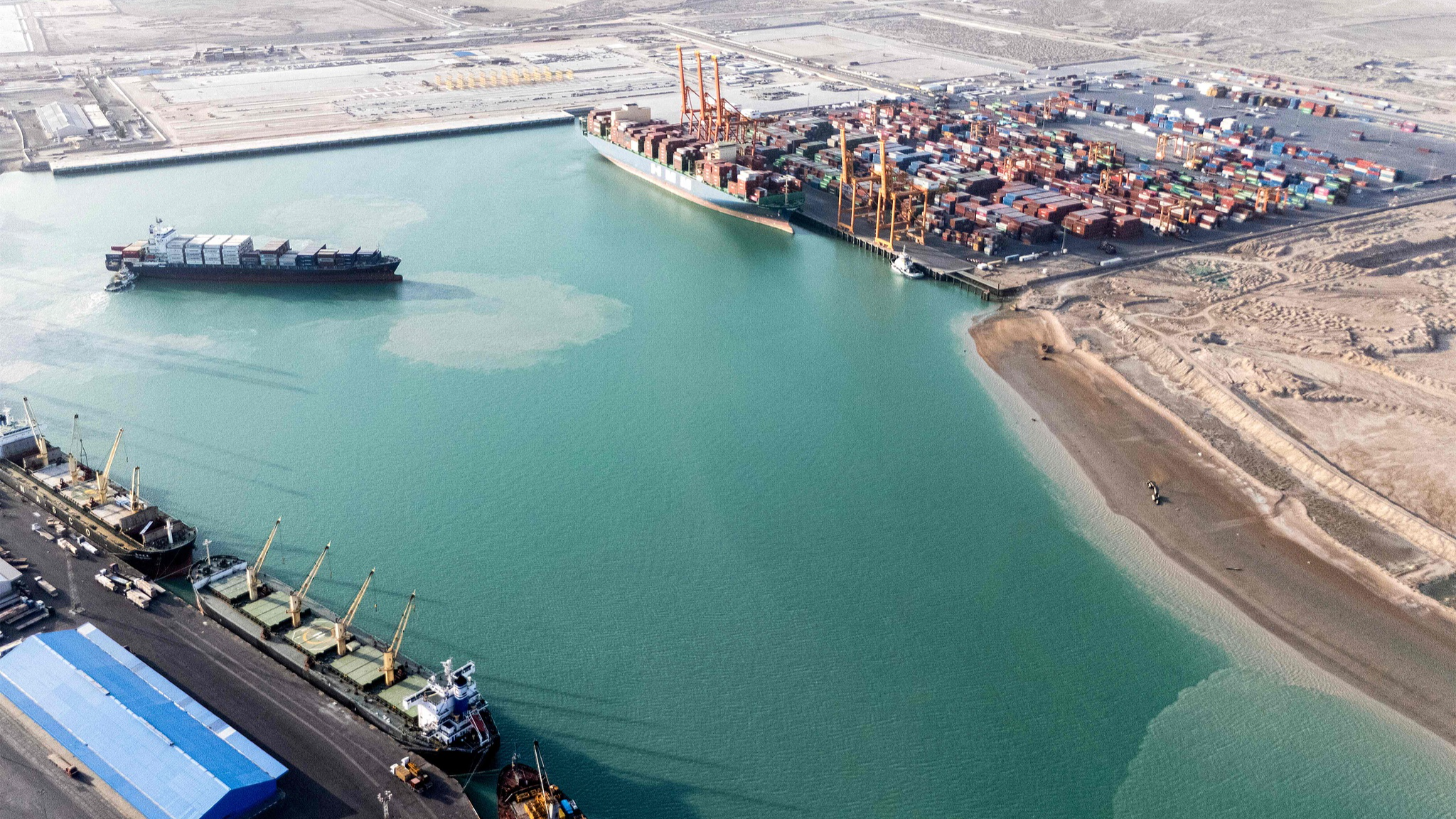 A tugboat assists a container ship at the port of Umm Qasr in Iraq's southern city of Basra, May 26, 2025. /VCG