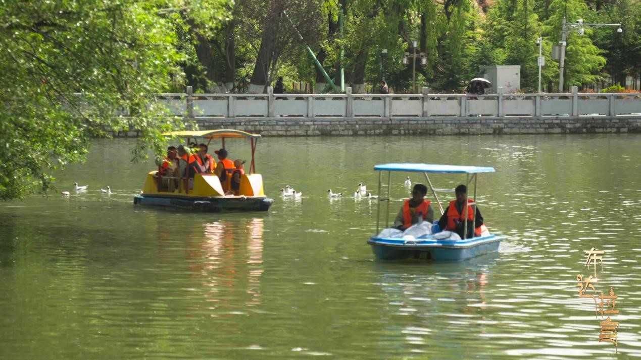 Visitors take a boat ride while enjoying the scenery at Longwangtan Park in Lhasa, Xizang. /CGTN