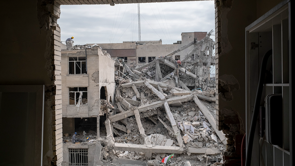 An Iranian man works on the ruins of buildings that were destroyed during the US-Israeli military campaign in Tehran, Iran, March 12, 2026. /VCG