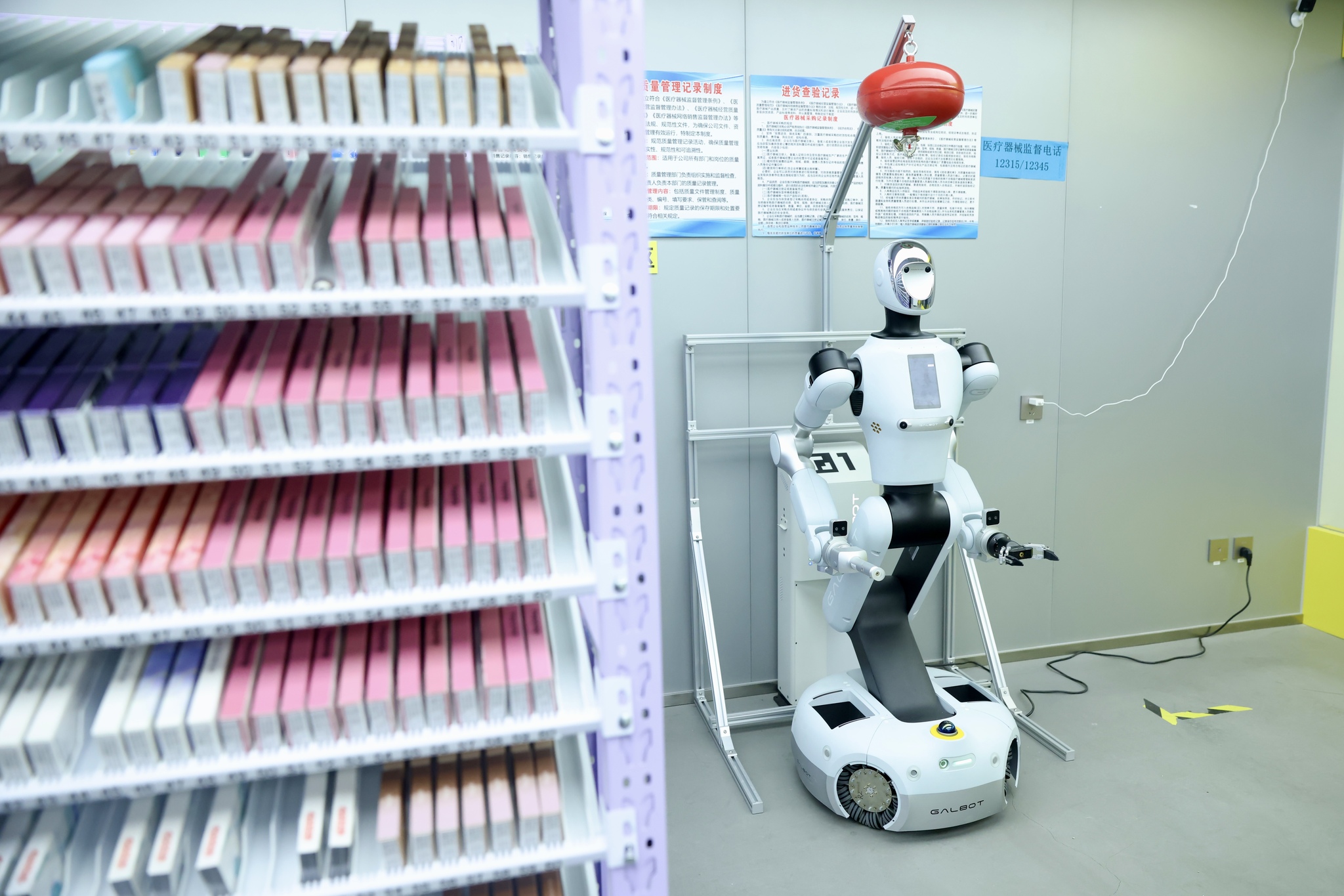 The intelligent pharmacy robot charges while on standby at a drugstore in Haidian District, Beijing, March 12, 2026. /VCG