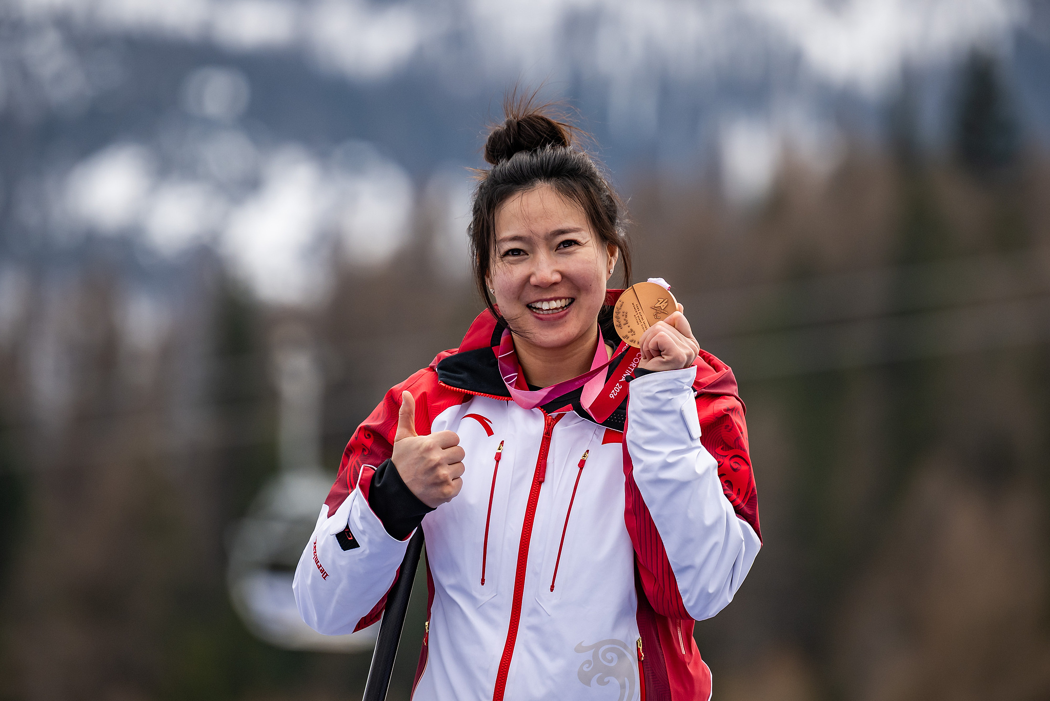 Bronze medalist Liu Sitong of China celebrates during the awards ceremony following the women's giant slalom sitting competition at the 2026 Milano Cortina Winter Paralympics at the Tofane Alpine Skiing Centre in Cortina d'Ampezzo, Italy, March 12, 2026. /VCG