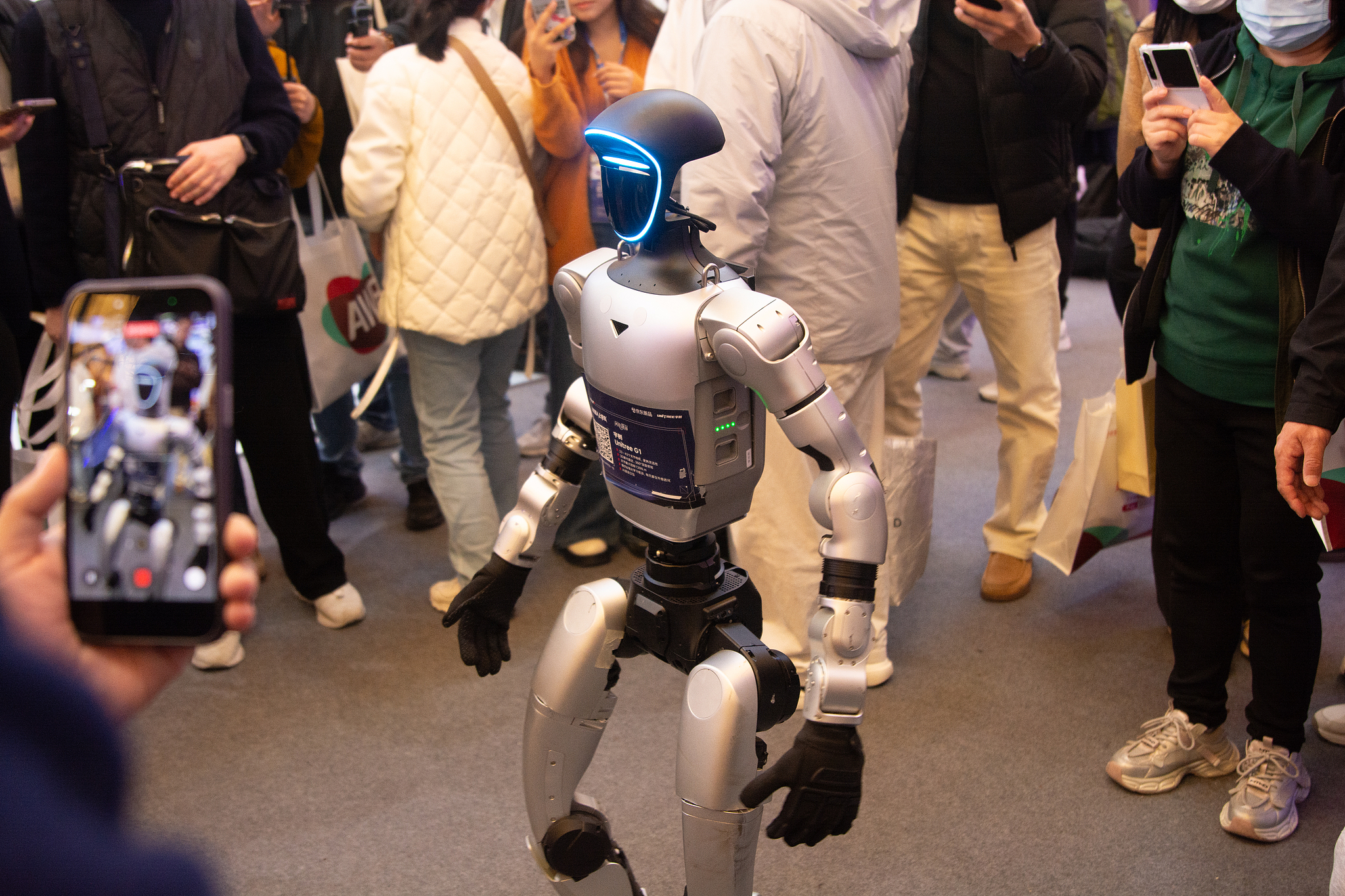 People interact with a robot during the second day of the AWE 2026 trade fair at SNIEC in Shanghai, China, on March 13, 2026. /VCG