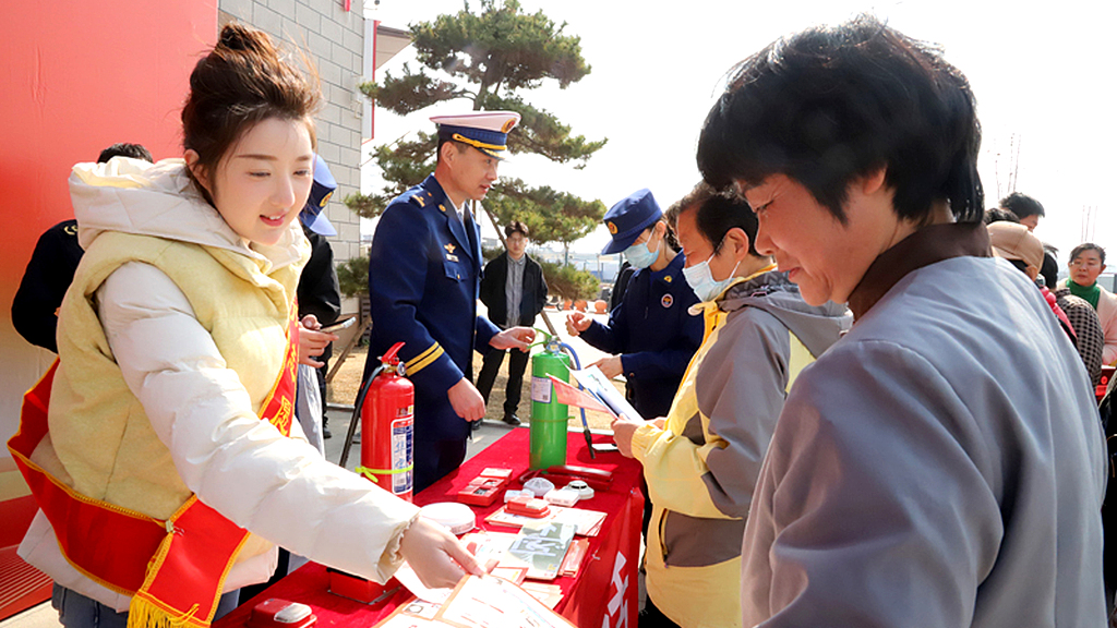 A social worker and firefighters promote knowledge about fire safety to residents in a neighborhood, Zaozhuang City, east China's Shandong Province, March 13, 2026. /VCG