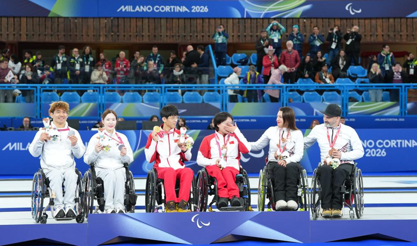 Chinese gold medalists Yang Jinqiao (3rd L)/Wang Meng (3rd R), South Korean silver medalists Lee Yongsuk (1st L)/Baek Hyejin (2nd L), and Latvian bronze medalists Polina Rozkova (2nd R)/Agris Lasmans attend the awarding ceremony for the wheelchair curling mixed doubles event at the Milano Cortina 2026 Paralympic Winter Games in Cortina d'Ampezzo, Italy, March 11, 2026. /Xinhua