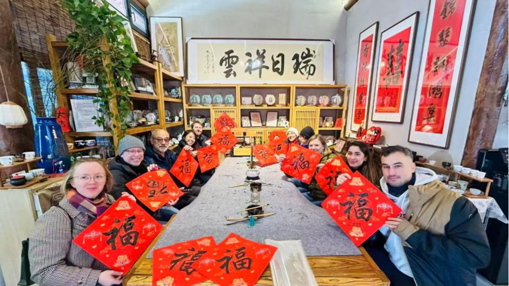 Foreign tourists experience Chinese calligraphy in Beijing, capital of China, December 2025. /Xinhua