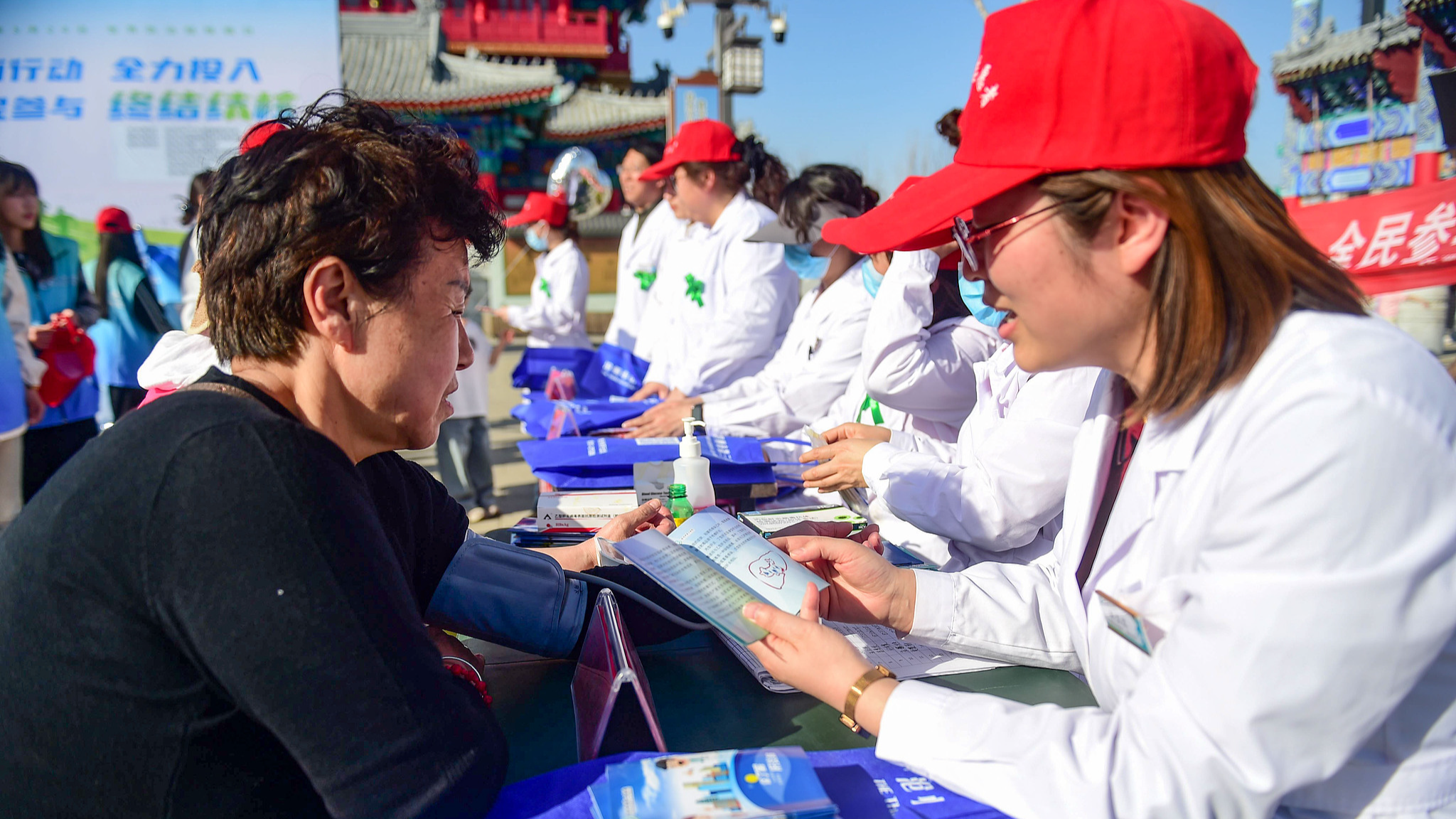 Medical staff explain tuberculosis prevention and control knowledge to people at an event in Cangzhou, north China's Hebei Province, March 22, 2025. /VCG