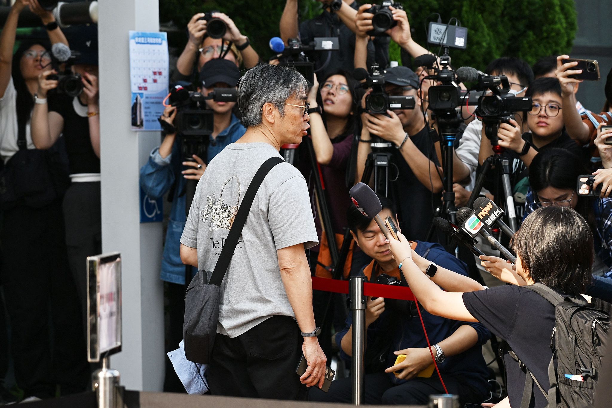 Journalists speak to a participant as he arrives to the public hearings into the Tai Po fire, China's Hong Kong Special Administrative Region (HKSAR), on March 19, 2026. /VCG