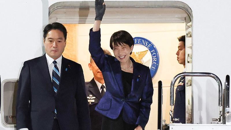 Japan's Prime Minister Sanae Takaichi (R) waves to people as she departs for the US at Tokyo's Haneda Airport, March 18, 2026. /CFP