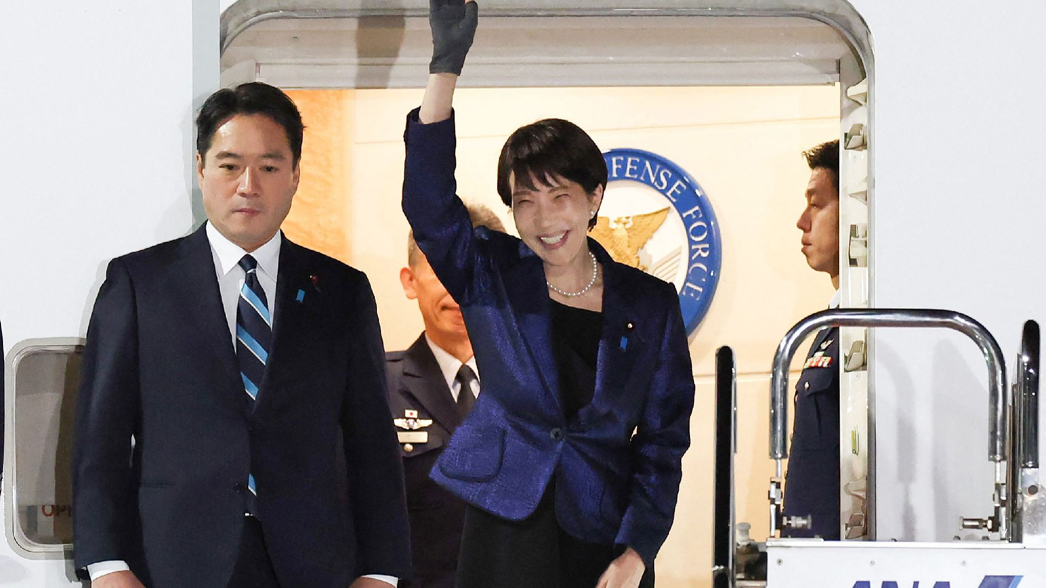 Japan's Prime Minister Sanae Takaichi (R) waves to people as she departs for the US at Tokyo's Haneda Airport, March 18, 2026. /CFP