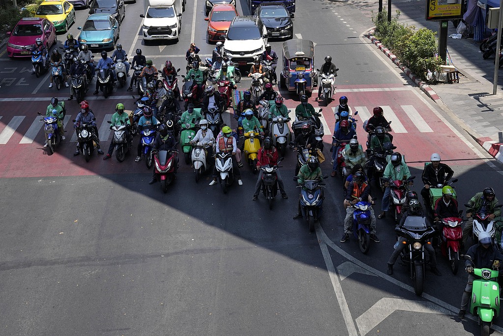 Motorcyclists stop in the shade of a skytrain line on a hot day in Bangkok, Thailand, May 3, 2025. /CFP