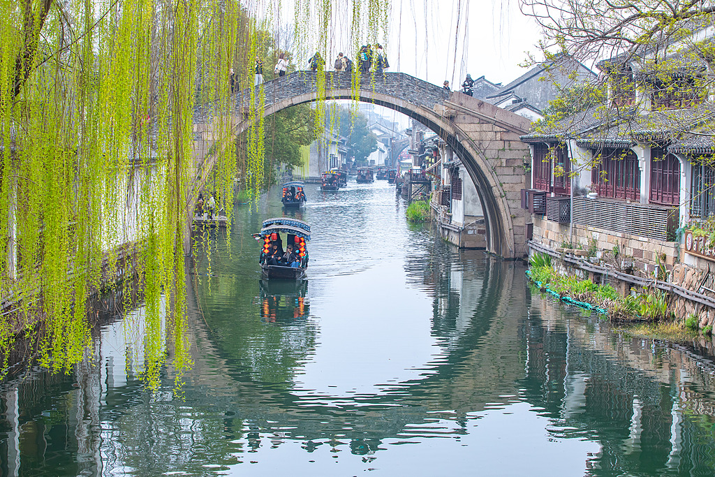 Boats slide through canals as visitors fill the narrow streets in Nanxun Ancient Town of Huzhou, Zhejiang Province on March 19, 2026. /VCG