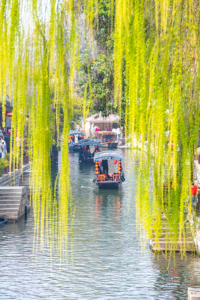 Boats slide through canals as visitors fill the narrow streets in Nanxun Ancient Town of Huzhou, Zhejiang Province on March 19, 2026. /VCG
