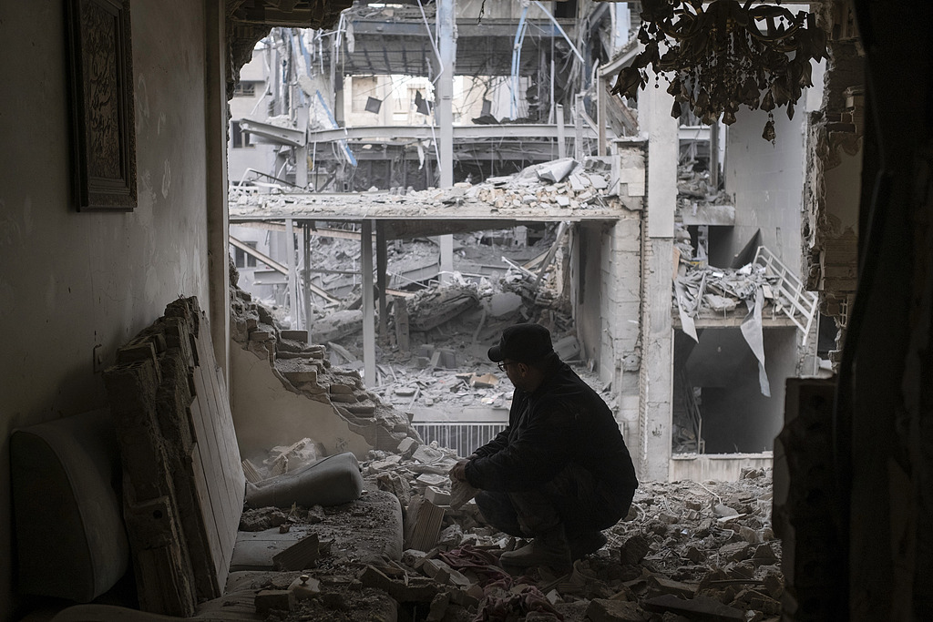 A man searches for his belongings among the ruins of his apartment near a police station in a residential area in Tehran, Iran, March 15, 2026. /VCG