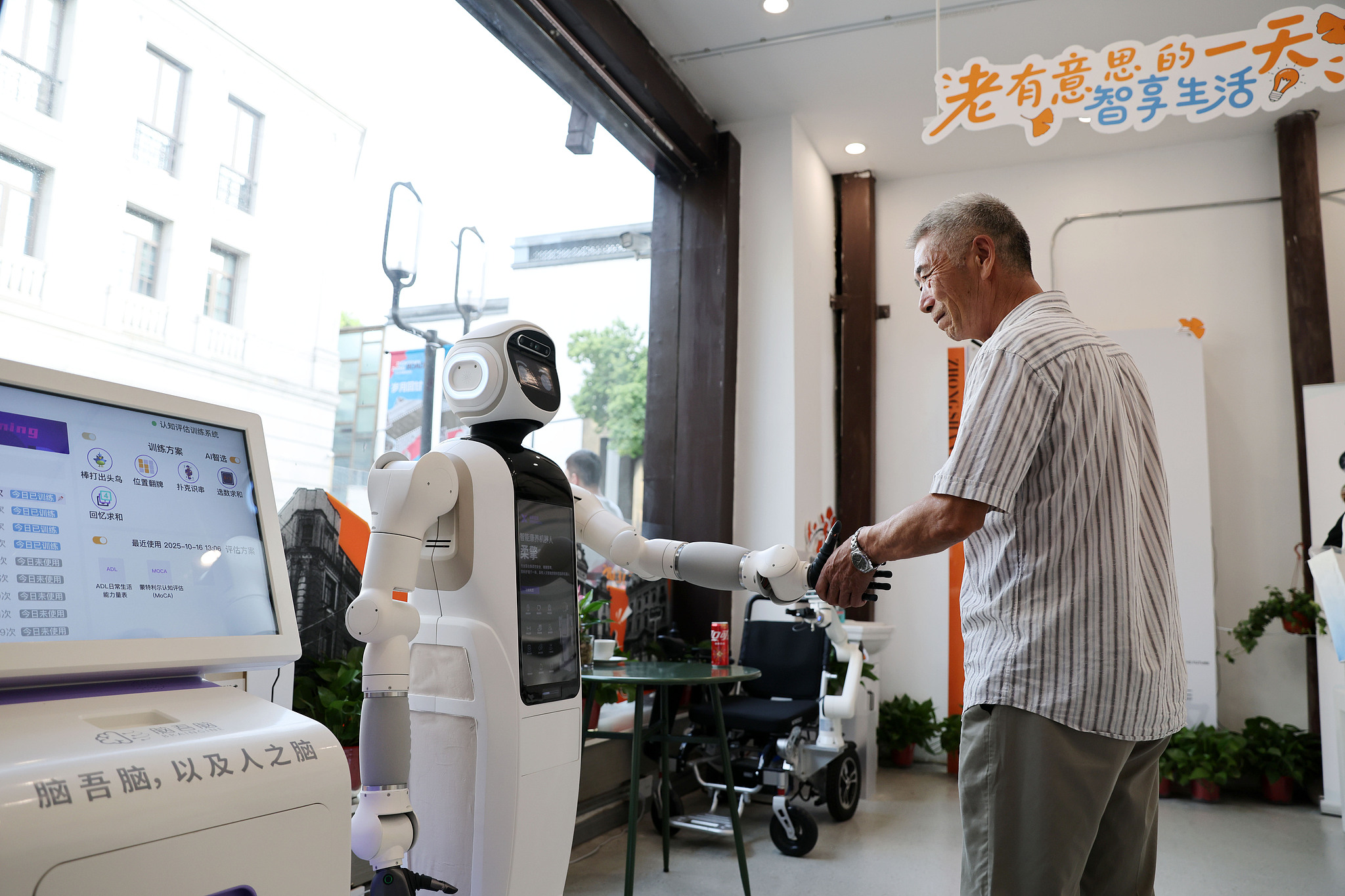 An elderly resident interacts with an AI-powered eldercare robot in Hangzhou city of Zhejiang Province, east China, October 16, 2025. /VCG