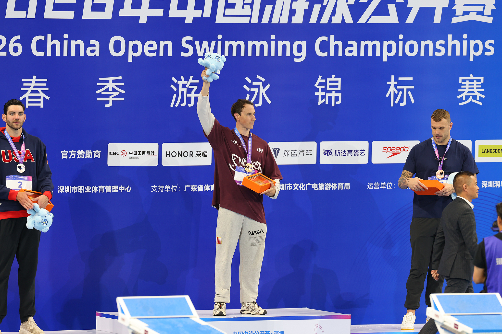 Gold medalist Cameron McEvoy (C) of Australia celebrates on the podium after winning the men's 50-meter freestyle final in a world record time of 20.88 seconds at the China Open Swimming Championships in Shenzhen, south China's Guangdong Province, March 20, 2026. /VCG