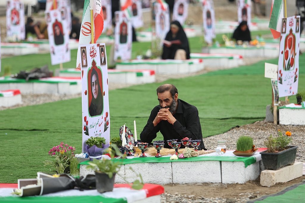 Iranians gather at a cemetery to commemorate victims, most of them children, who were killed in a US-Israeli attack on a girls' primary school in Minab, Hormozgan province, Iran, March 20, 2026. /VCG